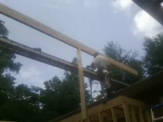 Carpenter setting a ridge beam over a new addition frame — Ice Dam Removal by Roofing Brothers in Sugar Land