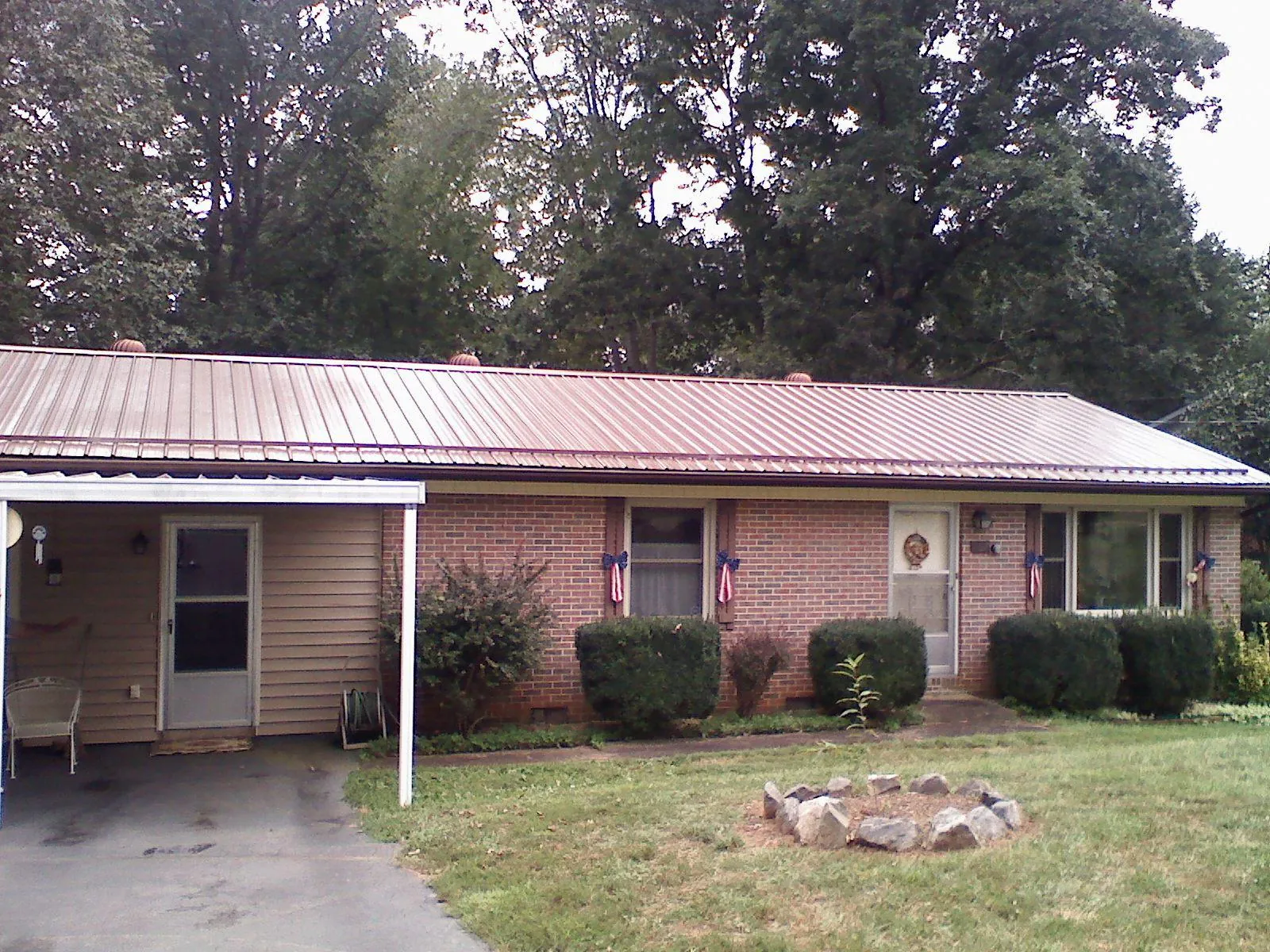 Bronze metal roof and carport on a brick ranch home — Roof Repair work by our crew in Sugar Land