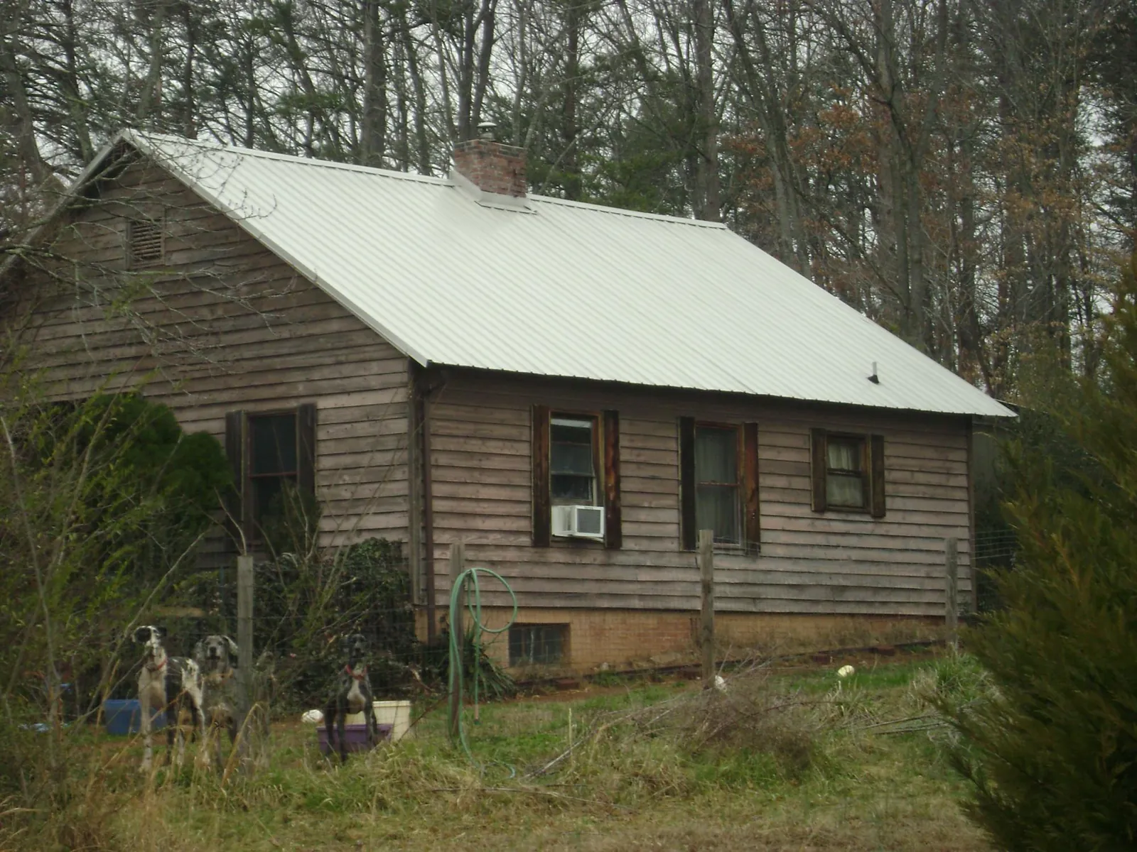 White metal roof on an old wood sided farmhouse, from a Metal Roof Installation job in Sugar Land